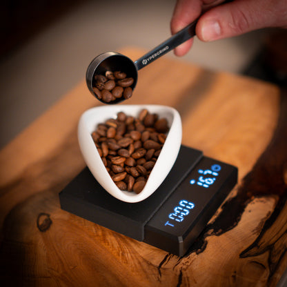 Coffee beans getting weighed on black coffee scales 