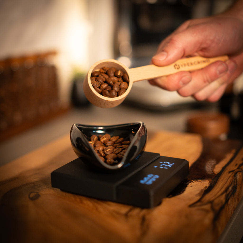 Coffee beans getting weighed on black coffee scales 